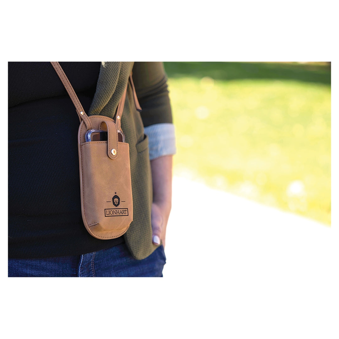 Personalized leather phone crossbody pouch in camel, styled lifestyle shot